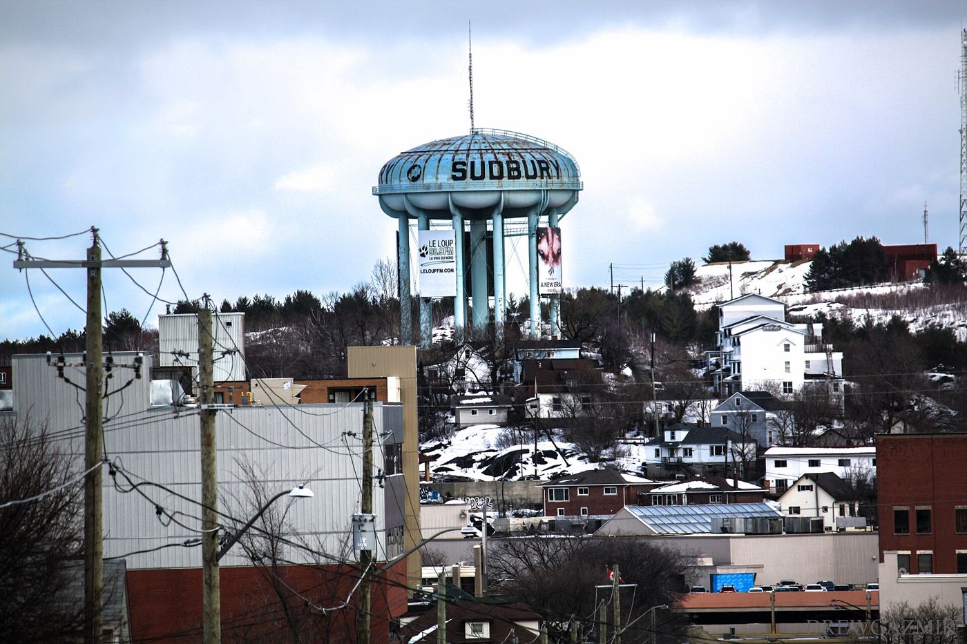 Sudbury's water tower above snowy rooftops in winter